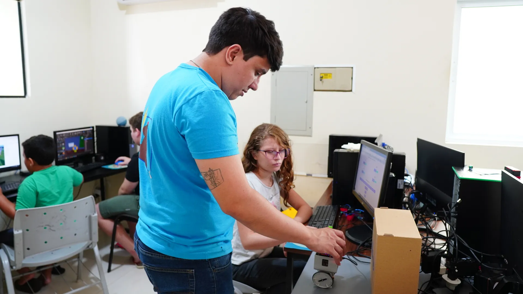 Instrutor auxiliando estudante em atividade no laboratório da CTRL 3D
