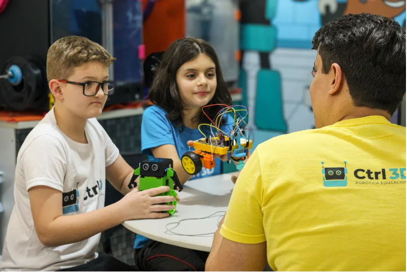 Professor orientando alunos em uma atividade de robótica da CTRL 3D